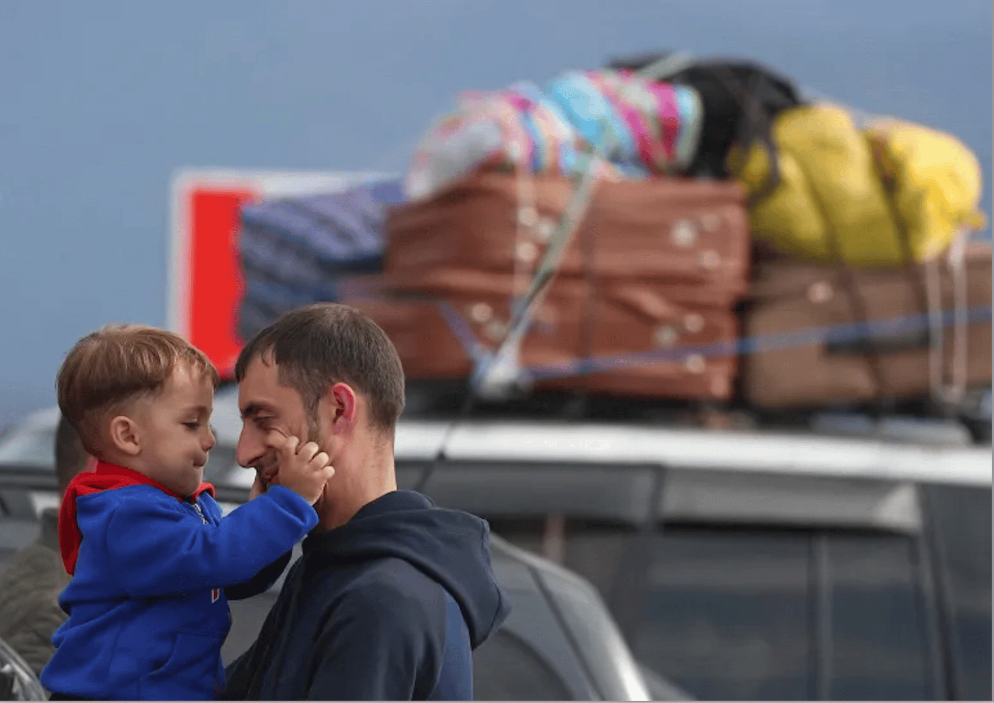 Un réfugié du Haut-Karabakh et un enfant à leur arrivée  au village frontalier de Kornidzor, en Arménie. Photo: Irakli Gedenidze/Reuters]