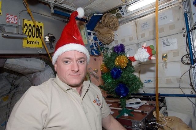 12 Dec. 2010. Wearing a Santa Claus hat, NASA astronaut Scott Kelly, Expedition 26 commander, poses for a holiday photo near Christmas decorations in the Unity node of the International Space Station.