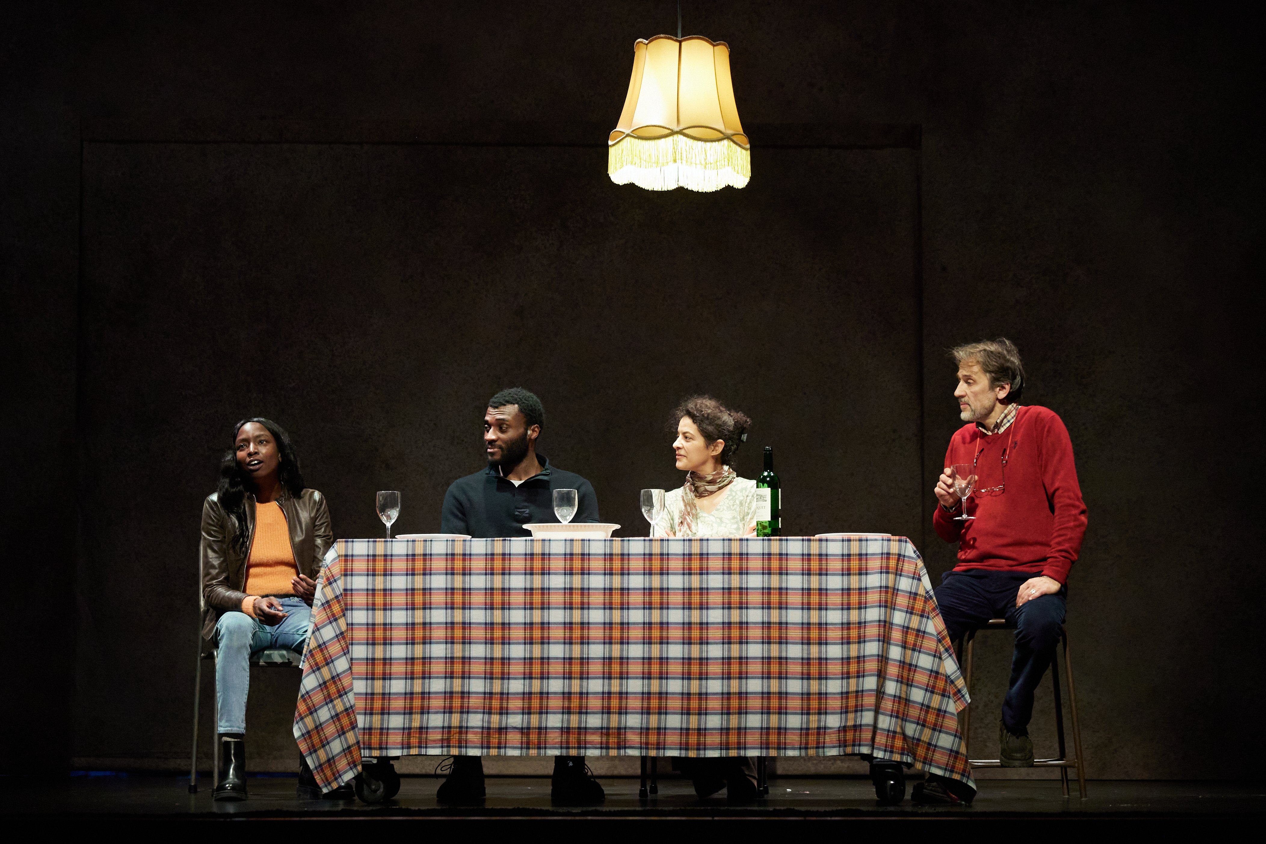 Une scène de "Passeport" où la journaliste (Manda Touré) ne se gêne pas pour recadrer le père raciste (en rouge, Patrick Blandin) 