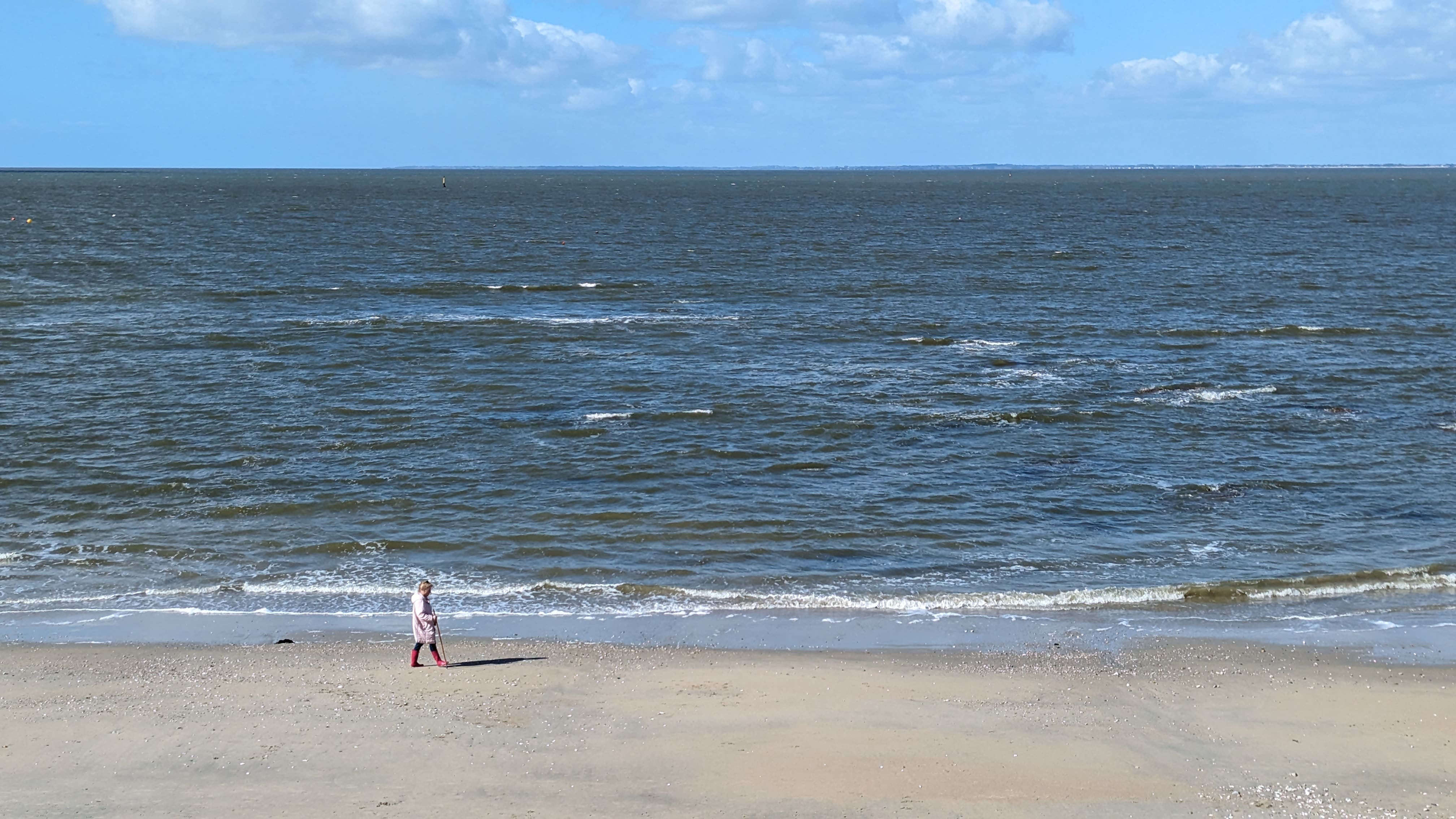 Une dame se balade avec sa canne et son ombre. J'ai bien aimé l'image.