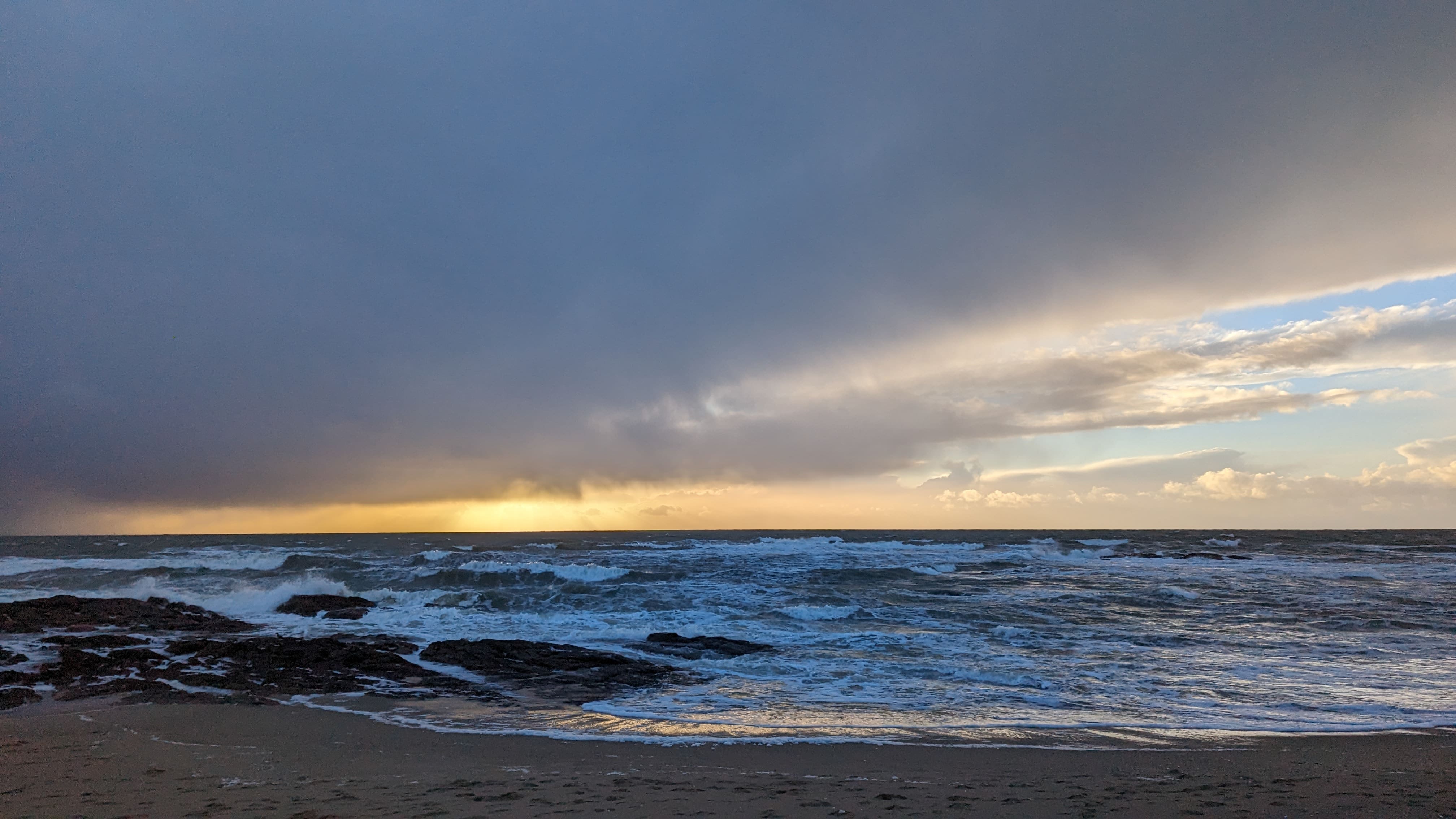 Sur la plage de La Turballe. Des rochers qui cassent une mer agitée, une lumière solaire qui s'endort et des nuages bien dessinés. Tout ce que j'aime.