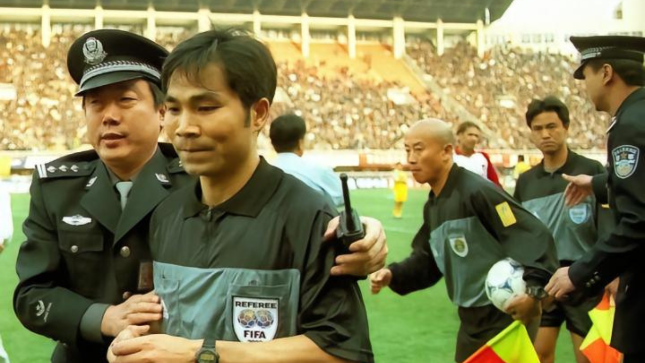 Face à une situation qui s'envenime, l'arbitre du match, Zhou Weixin, est évacué d'urgence par la police. Source image : dongquidi
