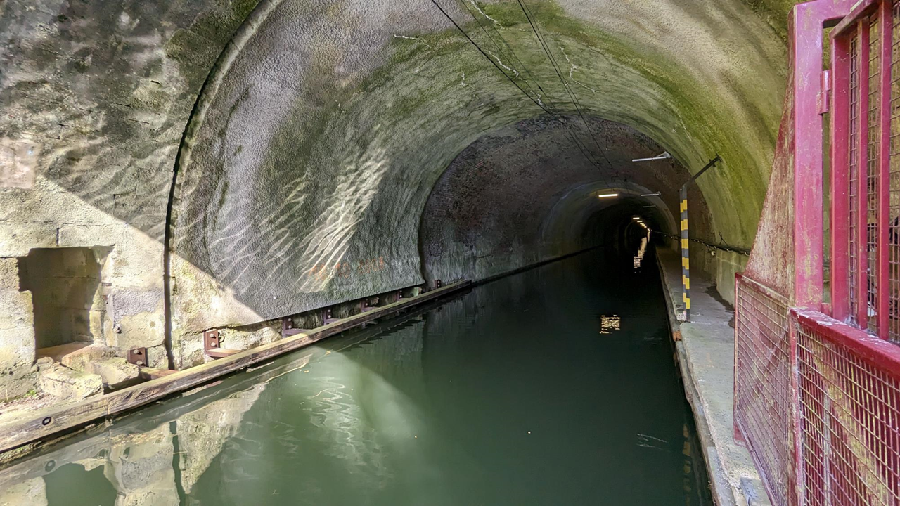 Le touage, c’est quoi ? En gros, un système qui permet, grâce à des chaînes, de guider les péniches et autres bateaux dans le tunnel. Ce dernier, long de 5,6km, a été inauguré par Napoléon Ier en 1810. L’idée était de pouvoir faire venir le charbon du Nord vers la capitale.