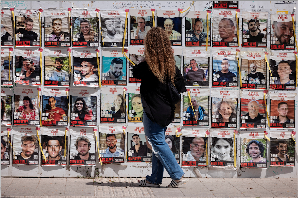 Une femme devant des affiches identifiant certain des otages du Hamas, à Tel Aviv, le 17 mai 2024. Photo: Nir Elias / Reuters