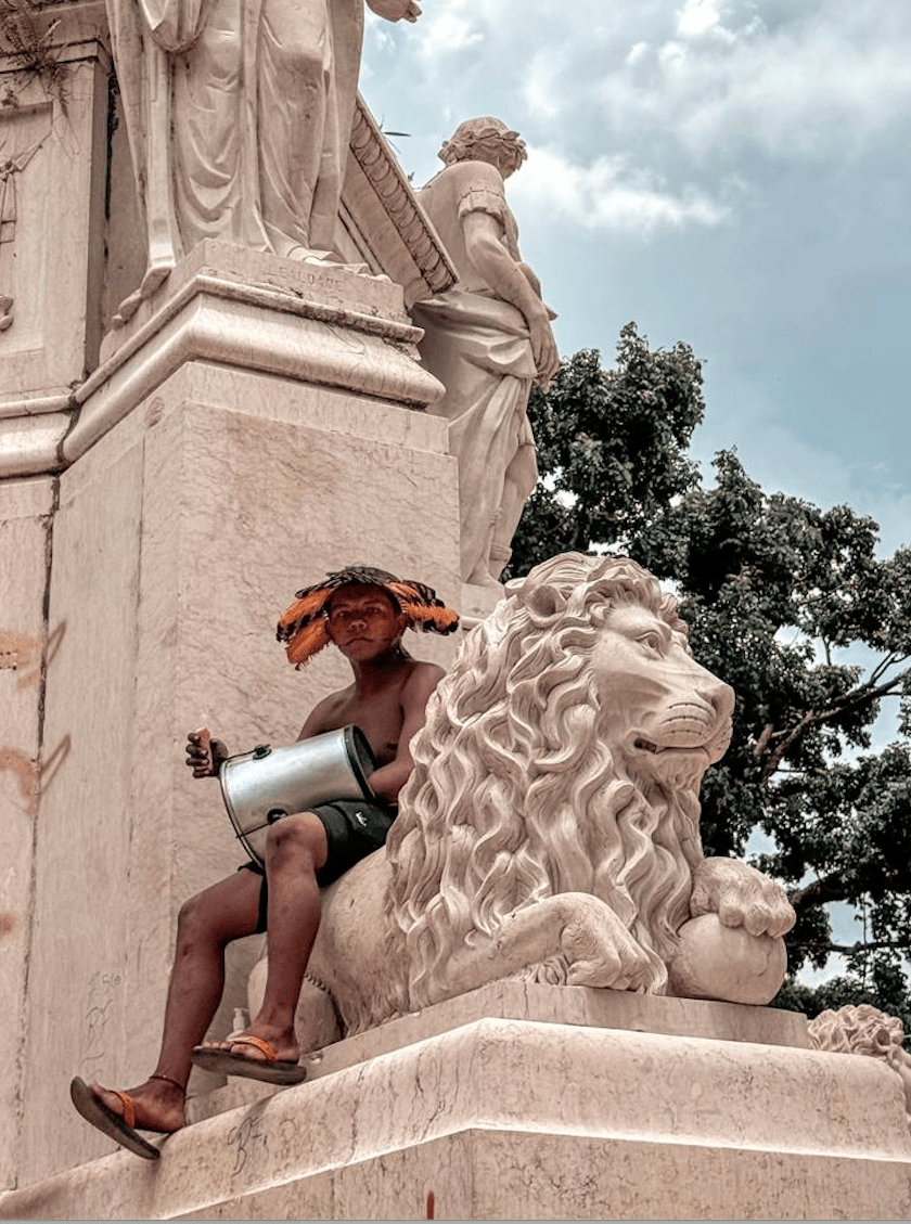 Jeune manifestant assis sur une statue devant l'assemblée (c) Dany Neves