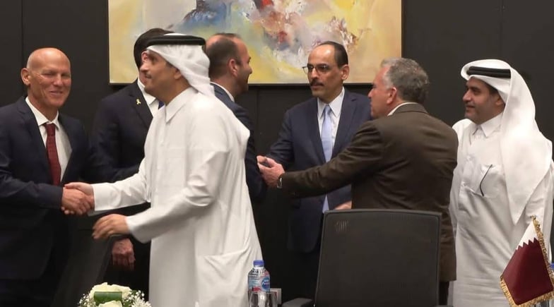 Le ministre qatari des Affaires étrangères serrant la main d’un des négociateurs israéliens