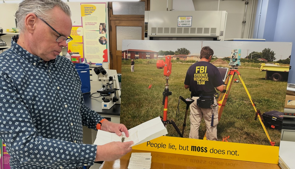 "Les gens mentent, mais la MOUSSE NE MENT PAS", dit la pancarte à côté du botaniste Matt von Konrat, qui tient les échantillons de mousse de l'affaire de Burr Oak. Crédit : Field Museum.