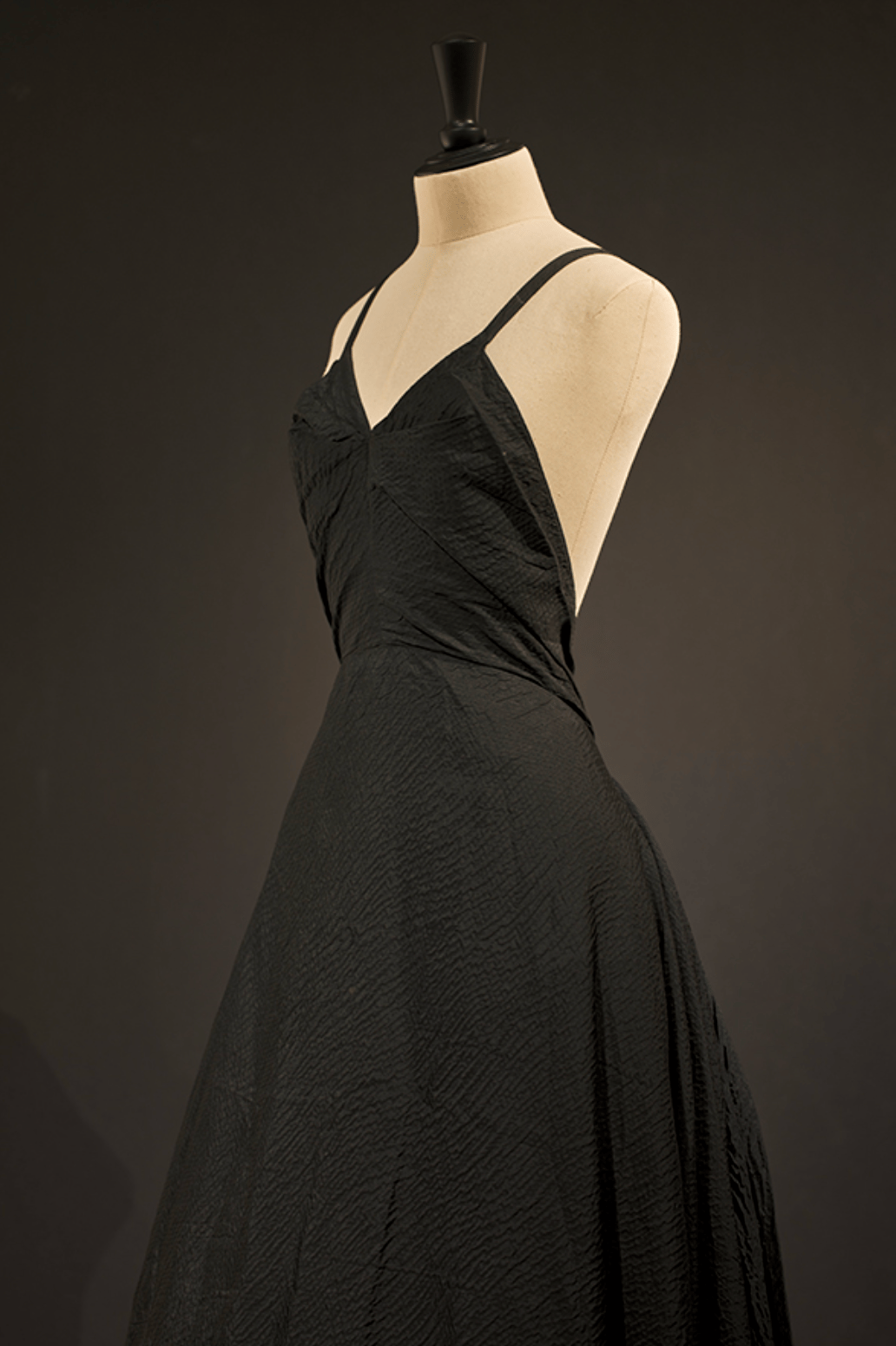 Longue robe du soir Madame Alix en faille de soie gaufrée noire doublée de tissu noir, corsage ajusté avec fines bretelles attachées au bas du dos, et jupe volumineuse. ©Colin Gray pour la Fondation Azzedine Alaïa
