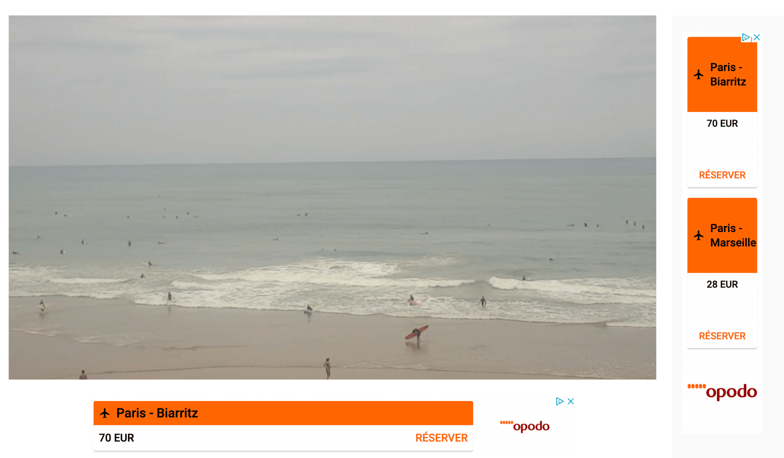 Des publicités vantant les bas prix de l'avion entourent la webcam de la plage de la côte des Basques, à Biarritz.